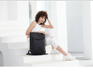 Black roll-top waterproof travel backpack with front flap and side carry handles