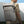 Light gray roll-top backpack with front zip pockets and vertical utility straps