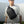 Minimalist sling bag in dark gray across chest on model, adjustable strap visible.