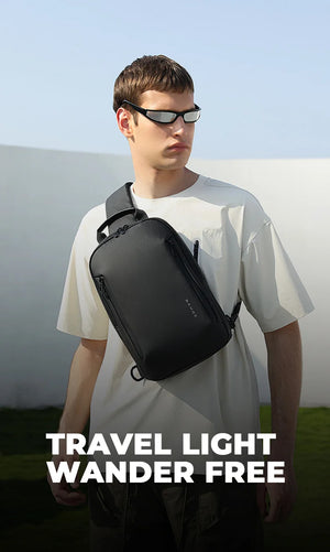 Minimalist sling bag in dark gray across chest on model, adjustable strap visible.