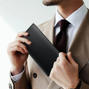 Black textured leather long wallet held open, card slots visible inside