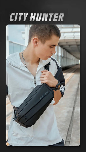 Black crossbody bag worn on shoulder with adjustable strap and top zip