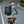 Black waterproof travel backpack worn while riding a bicycle, front pocket and shoulder straps