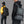 Black and gray travel backpack with front zip pocket, padded straps, and back view