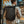 Black expandable roll-top backpack worn on back with adjustable shoulder straps