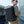Black waterproof backpack worn by a person, showing wide shoulder straps