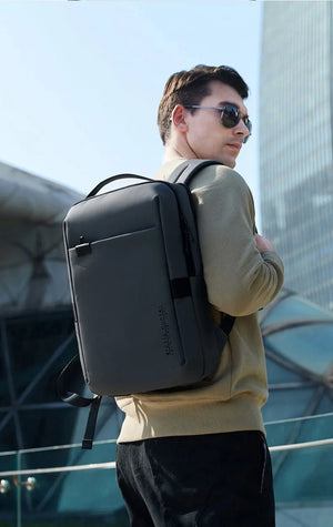 Black waterproof backpack worn by a person, showing wide shoulder straps