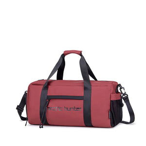 Red waterproof duffle bag with top handle, front zip, and adjustable shoulder strap