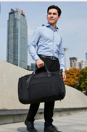 Black waterproof duffle and sports bag carried with top handles and shoulder strap