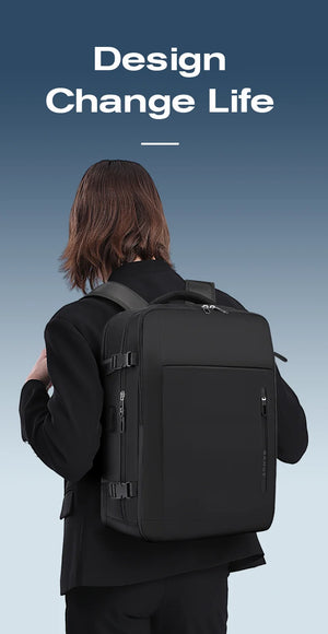 Black travel backpack on a person from back view with secured front buckle straps