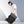 Black travel backpack worn on shoulder with front flap and adjustable straps.