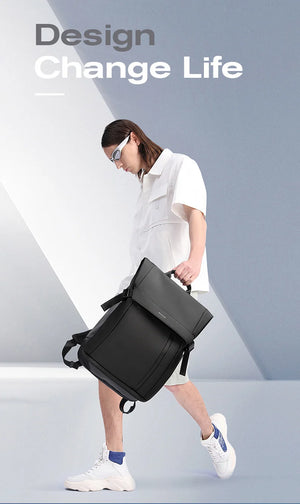Black travel backpack worn on shoulder with front flap and adjustable straps.