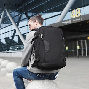 Black travel backpack worn on back with front straps and zip compartments