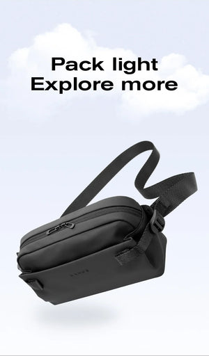 Black compact crossbody bag with top zipper and adjustable shoulder strap, angled view.