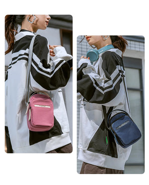 Waterproof crossbody bags in pink and navy worn crossbody with strap