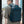 Blue waterproof travel backpack worn on back with padded straps and top handle