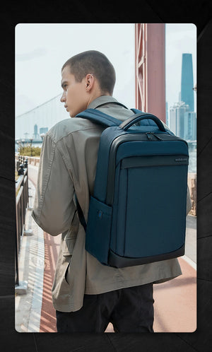 Blue waterproof travel backpack worn on back with padded straps and top handle