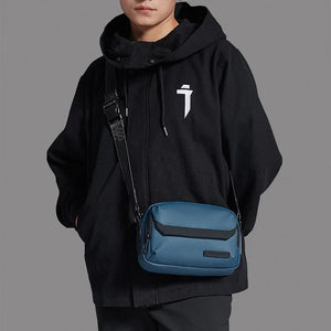 Blue crossbody bag with flap front and adjustable shoulder strap