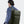 Olive green water-resistant travel backpack on person, back and side view