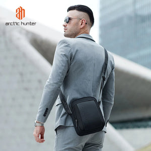 Compact messenger bag in dark black worn crossbody with adjustable shoulder strap
