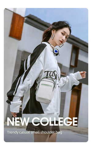 Small crossbody bag in white with green trim and adjustable shoulder strap