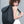 Grey roll-top backpack with front flap pocket and adjustable strap, worn on shoulder
