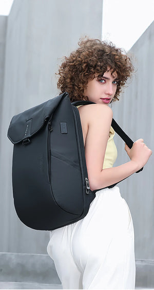 Grey roll-top backpack with front flap pocket and adjustable strap, worn on shoulder