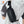 Black crossbody bag worn across chest; side view shows zip pocket and wide strap.