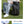 Blue and black travel backpack on seated person with side compartments and front zipper pockets