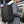 Black travel backpack worn on back with shoulder straps and front zip pocket