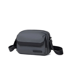 Black crossbody bag with zip top, front flap pocket, and adjustable shoulder strap