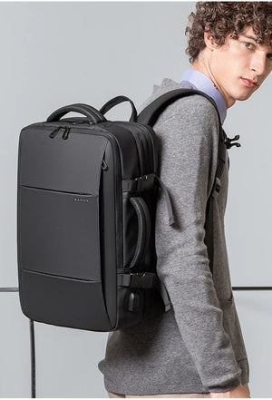 Black travel backpack worn on back with front panel zipper and cross-body strap