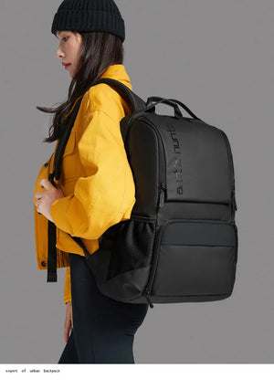 Black travel backpack worn on back with front zip pocket and adjustable straps