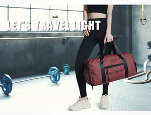 Waterproof duffel bag in red with front logo panel and shoulder strap worn crossbody