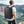 Black backpack worn on back with padded shoulder straps and curved back panel.