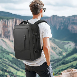 Black backpack worn on back with padded shoulder straps and curved back panel.