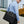Black waterproof laptop bag with top handle, shoulder strap, and front zip pocket