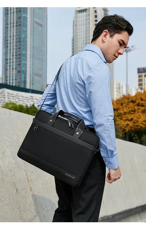 Black waterproof laptop bag with top handle, shoulder strap, and front zip pocket