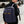 Navy waterproof commuter backpack worn with padded straps and front pocket