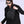 Black compact crossbody bag worn across the chest with adjustable shoulder strap