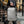 Light gray/black travel backpack standing upright with side handle and straps