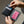Black bifold wallet open with credit cards in card slots, textured lining.