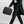 Black padded laptop sleeve carried by person, front zip pocket and handle visible.