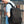 Black backpack worn on shoulders with front zipper pocket and side hanging strap