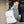 White compact laptop backpack with black trim, top handle, and padded back straps