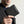 Black textured bifold wallet held in hand, showing front panel and side card slot