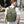 Green waterproof commuter backpack with front flap, buckled strap and top carry handle