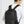 Black travel backpack worn by person, with front zipper pocket and top carry handle