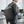 Black travel backpack worn at the side view with zip pocket and padded shoulder strap