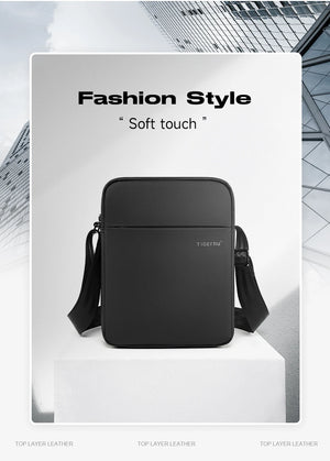 Black compact crossbody bag with top zip and small front logo patch